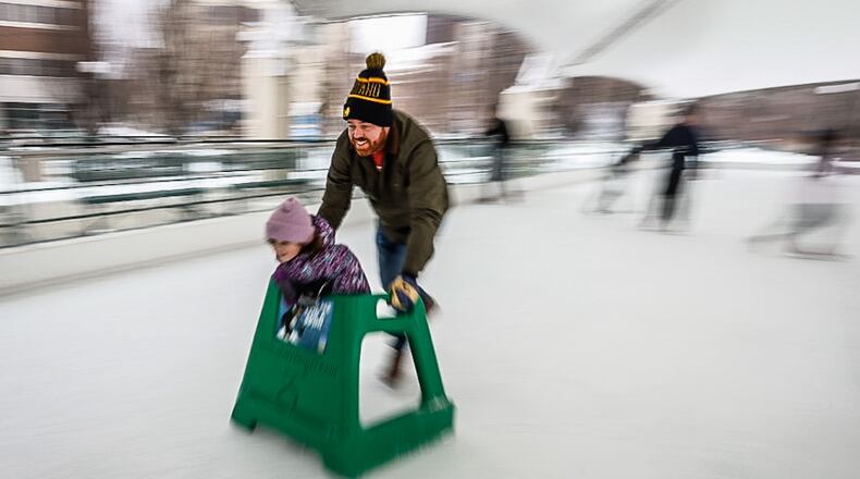John Bulfin and his daughter, Blaine cruise around the Metroparks ice rink at Riverscape Tuesday December 27, 2022. The Bulfin family is visiting family in Dayton over the holidays. JIM NOELKER/STAFF