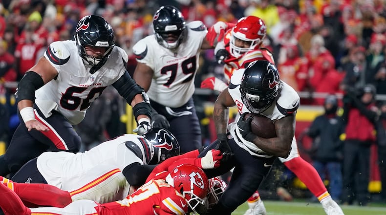 Houston Texans running back Dare Ogunbowale, right, scores past Kansas City Chiefs defensive back Chamarri Conner during the second half of an NFL football game Wednesday, Jan. 7, 2026, in Kansas City, Mo. (AP Photo/Ed Zurga)