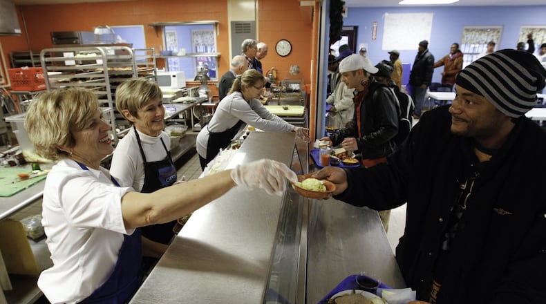 Paula MacIlwaime of Oakwood, a volunteer at the House of Bread, serves a salad to Rodrick C. Smith of Dayton. The House of Bread serves a lunch time meal to anyone in need all week long. Eighty percent of the food they serve comes from The Foodbank.