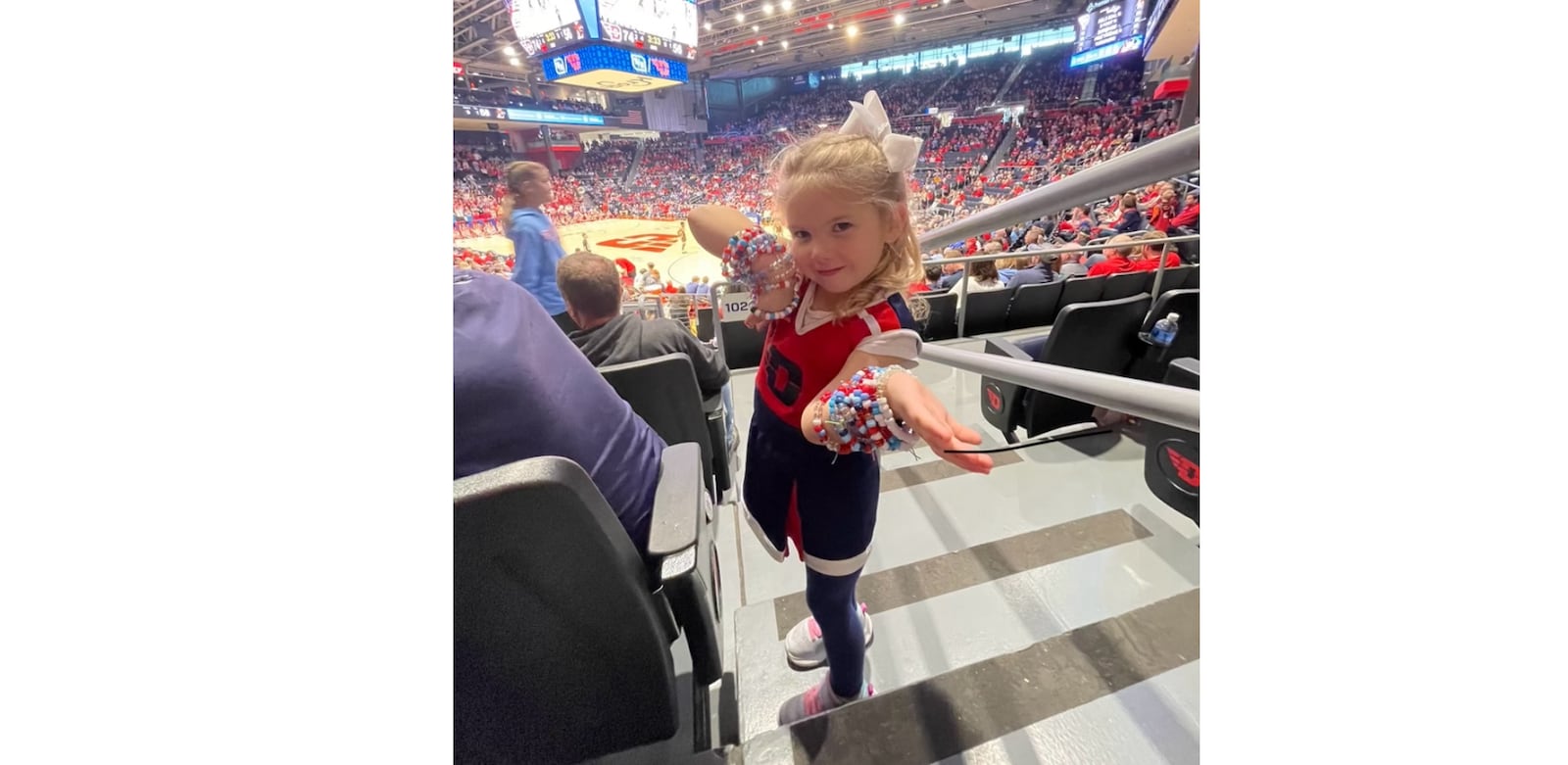 Dayton fan Caroline Kremer, 4, shows off the friendship bracelets she made for the Flyers players and cheerleaders at UD Arena during a game in 2025. Contributed photo