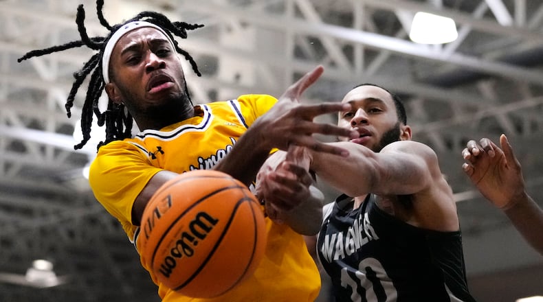 Wagner guard Tahron Allen, right, ands Merrimack forward Bryan Etumnu vie for a rebound during an NCAA college basketball gam for the Northeast Conference men's tournament title Tuesday, March 12, 2024, in North Andover, Mass. (AP Photo/Charles Krupa)
