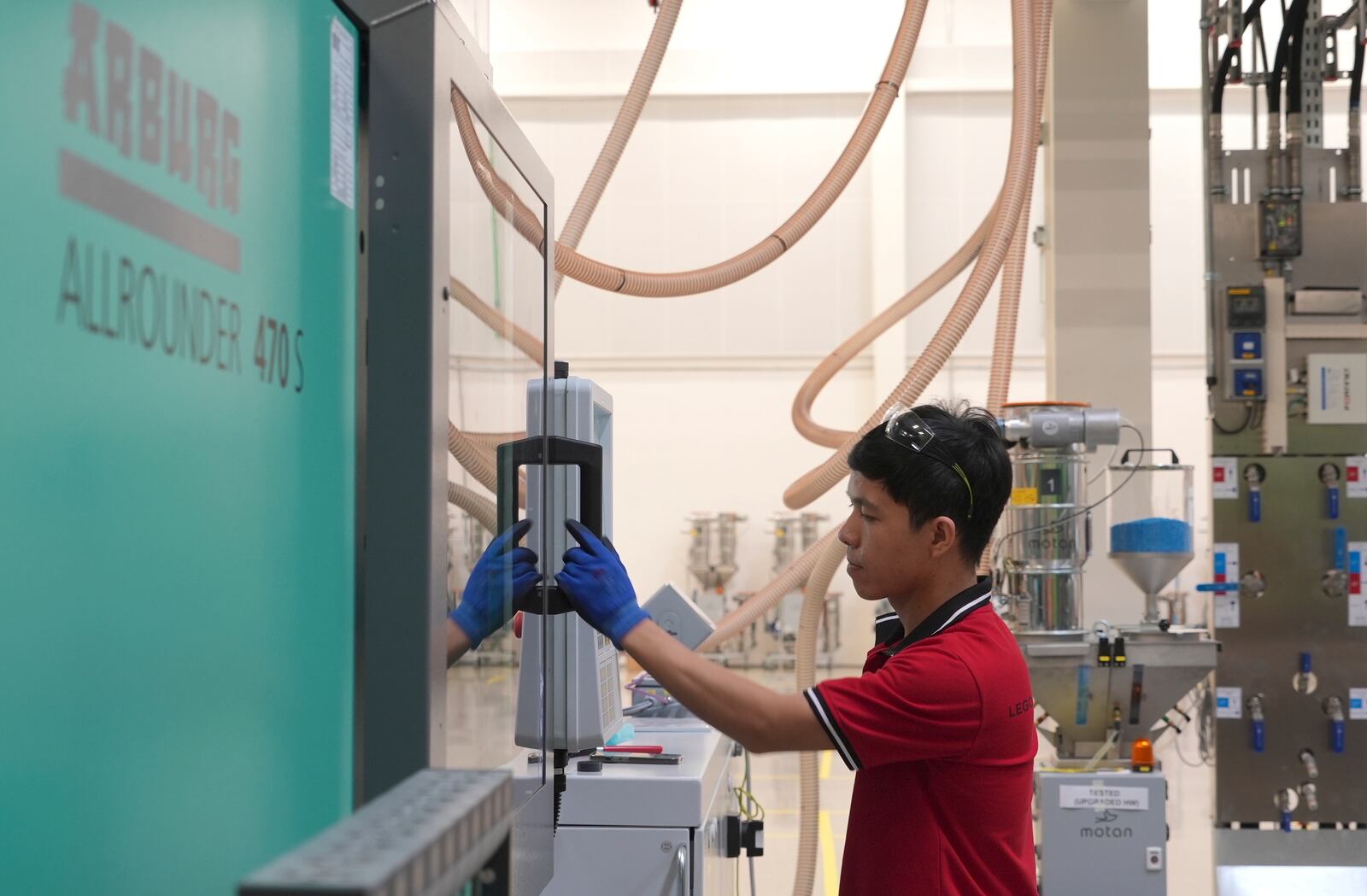 A worker operates a moulding machine at Lego factory in Binh Duong, Vietnam Wednesday, April 2, 2025. (AP Photo/Hau Dinh)