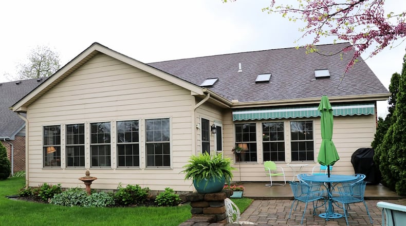 The main bedroom and the great room are accessible to the sunroom, which has a panoramic view of the tree-lined back yard. A door from the sunroom opens to a concrete patio with paver-brick patio extension.