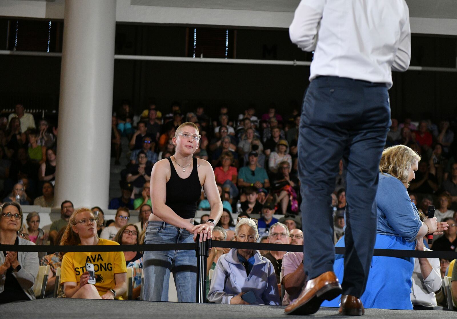 Ava Jones of Iowa City, a traumatic brain injury survivor and currently battling stage four Hodgkins lymphoma, asks former U.S. Secretary of Transportation Pete Buttigieg a question about the impacts of cuts to medical research and educational institutions during a VoteVets Townhall, Tuesday, May 13, 2025, in Cedar Rapids, Iowa. (AP Photo/Cliff Jette)