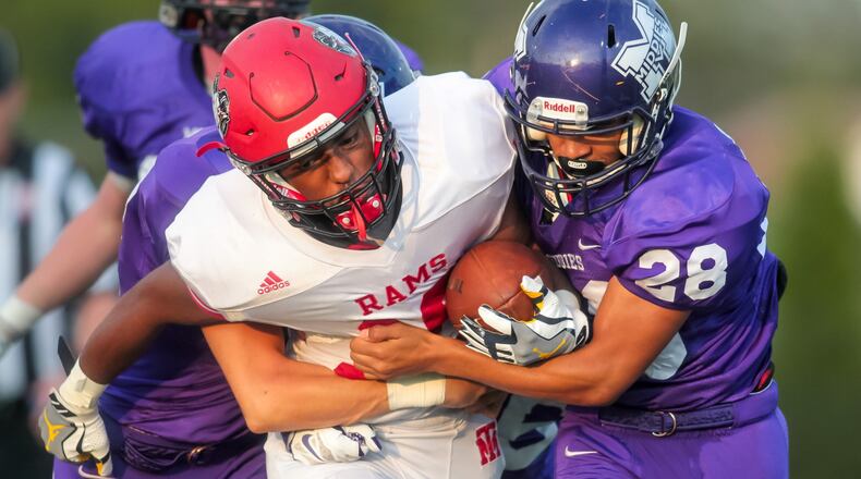 Trotwood-Madison’s Tedrian Satterwhite (with ball) is tackled by Middletown’s Cameron Dillingham. Trotwood won the Week 3 game, 42-0. NICK GRAHAM/STAFF