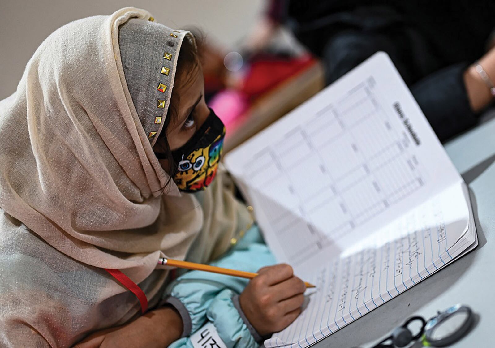 An Afghan student writes out her ABCs during community-based education in Liberty Village, Joint Base McGuire-Dix-Lakehurst, New Jersey, Dec. 20. U.S. AIR FORCE PHOTO/TECH. SGT. RION EHRMAN