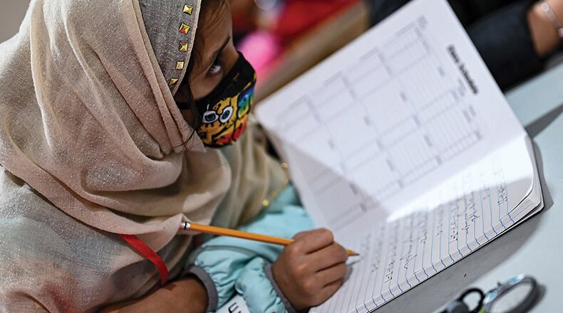 An Afghan student writes out her ABCs during community-based education in Liberty Village, Joint Base McGuire-Dix-Lakehurst, New Jersey, Dec. 20. U.S. AIR FORCE PHOTO/TECH. SGT. RION EHRMAN