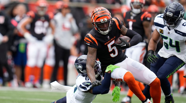 Cincinnati Bengals' Tee Higgins (5) is tackled by Seattle Seahawks' Quandre Diggs (6) during the first half of an NFL football game, Sunday, Oct. 15, 2023, in Cincinnati. (AP Photo/Michael Conroy)