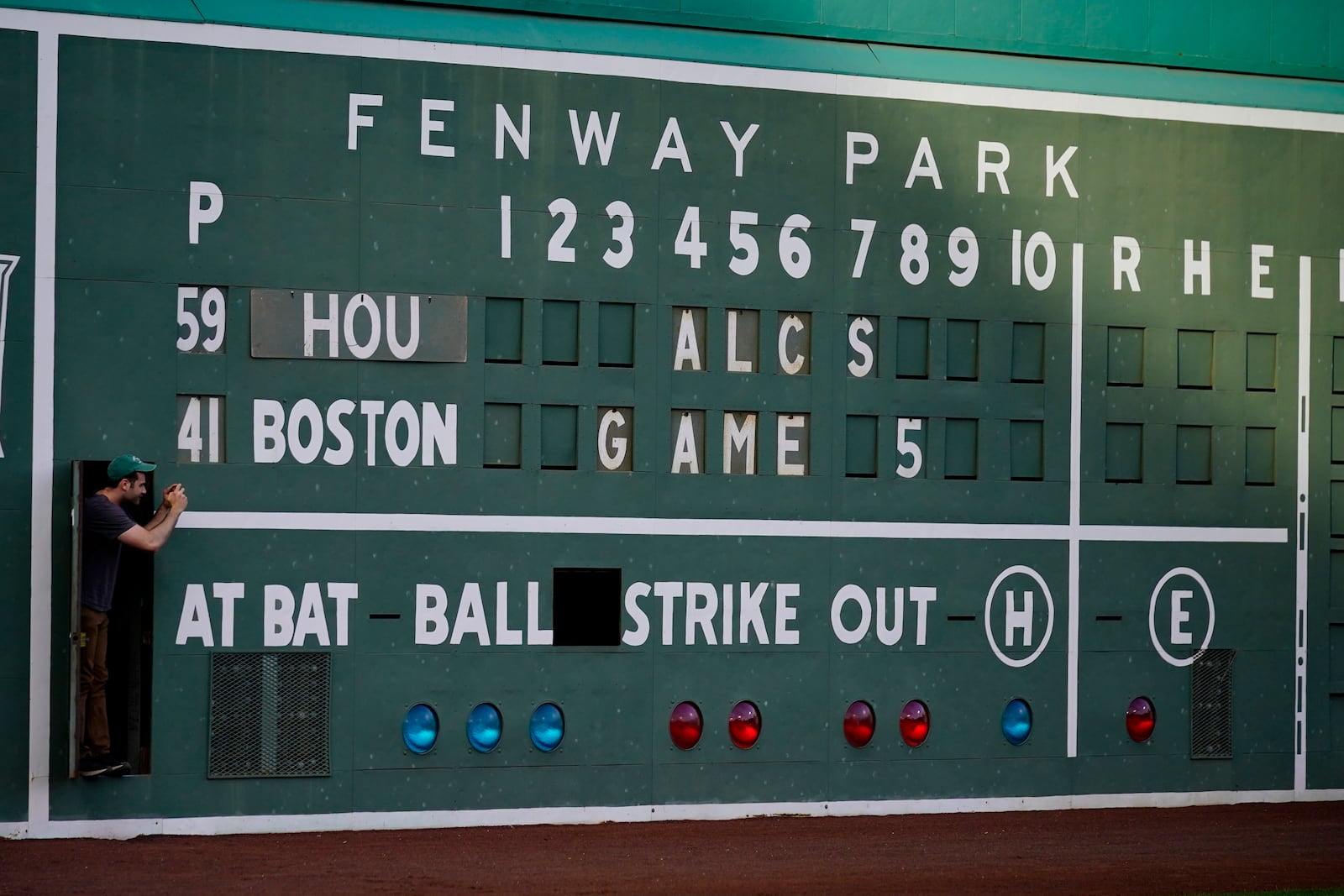 A scoreboard worker takes a picture before a game in this Oct. 20, 2021 file photo, in Boston. (AP Photo/Robert F. Bukaty)