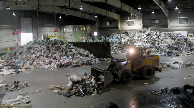 Heavy equipment moves piles of trash on the tipping floor at the Montgomery County Solid Waste transfer station in Moraine.   LISA POWELL / STAFF