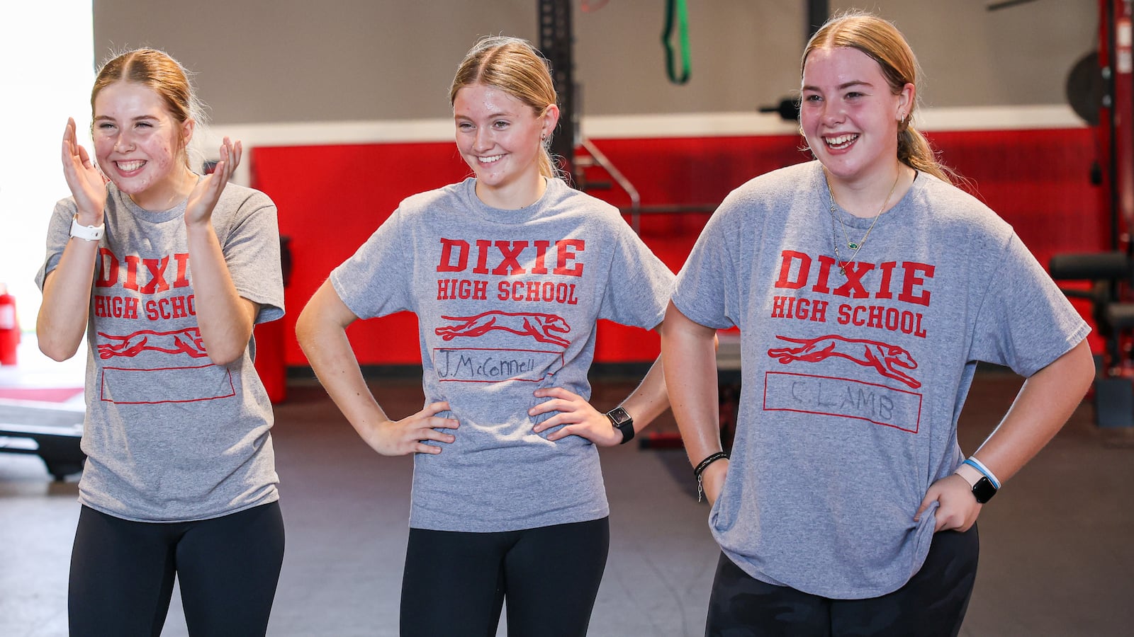 From left to right, Dixie High School junior Mylie Palmer, sophomore Jaelyn McConnell and freshman Chelsea Lamb react after a question from teacher Jonathon Hutchison after completing a "Murph," workout during a weight training class on Wednesday, Nov. 5 in the school's weight room facility in New Lebanon. Students in Hutchison's fifth period class researched soldiers who inspired the workouts as part of the project. BRYANT BILLING/STAFF