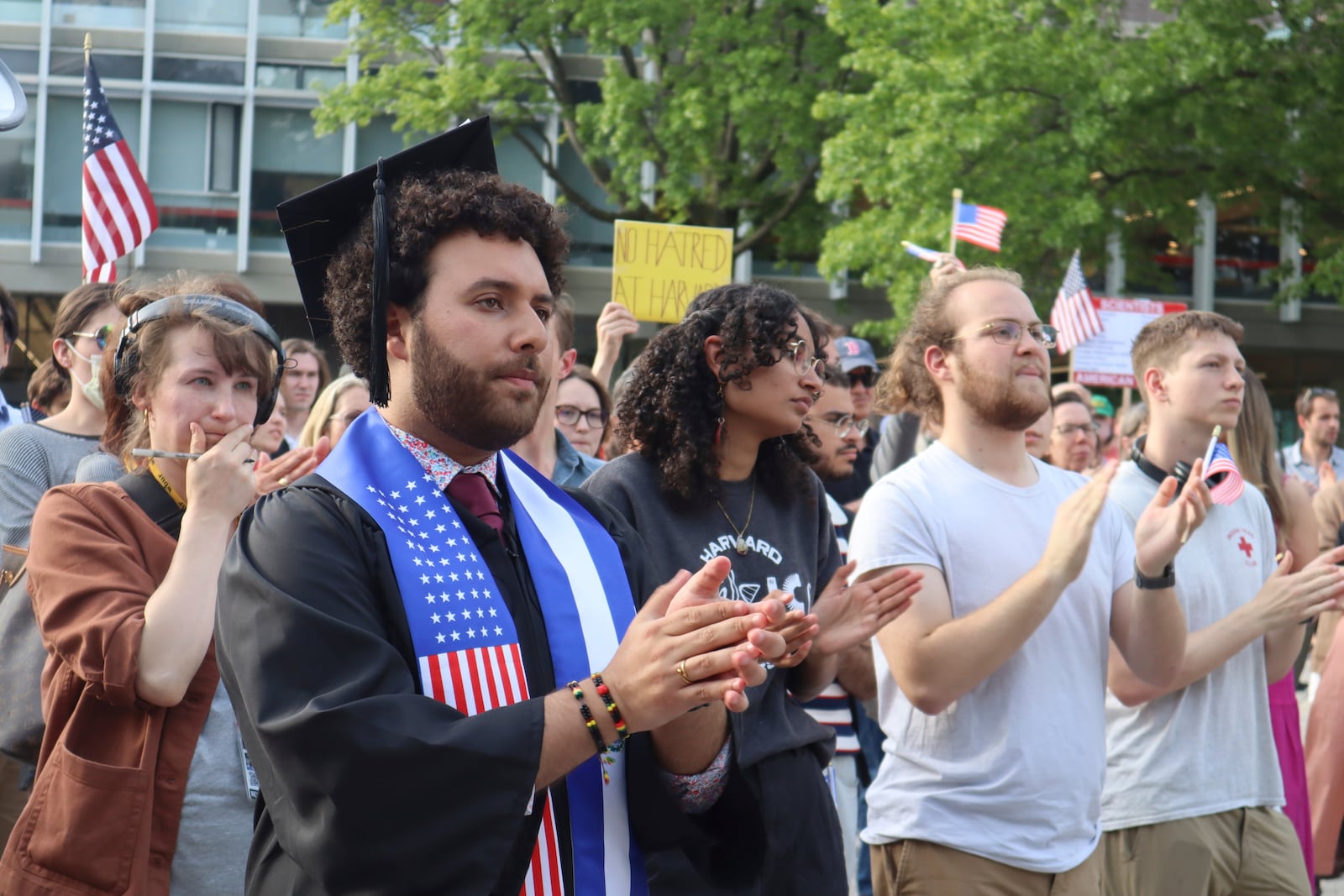 Harvard University graduating senior Victor Flores claps while listening to a fellow student speak at a protest against President Donald Trump's recent sanctions against Harvard in front of Science Center Plaza on Tuesday, May 27, 2025, in Cambridge, Mass. (AP Photo/Leah Willingham)