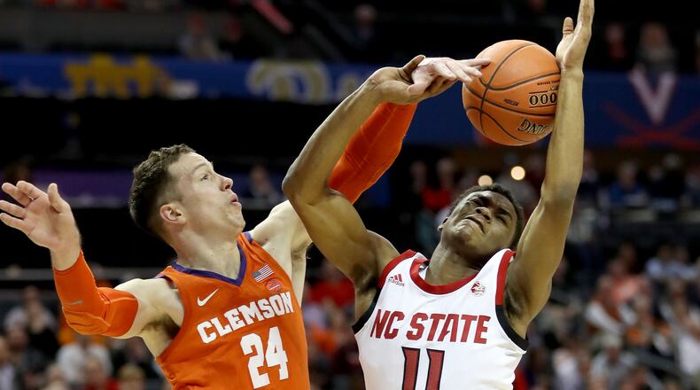 CHARLOTTE, NORTH CAROLINA - MARCH 13: Markell Johnson #11 of the NC State Wolfpack drives to the basket against Devon Daniels #24 of the Clemson Tigers during their game in the second round of the 2019 Men’s ACC Basketball Tournament at Spectrum Center on March 13, 2019 in Charlotte, North Carolina. (Photo by Streeter Lecka/Getty Images)