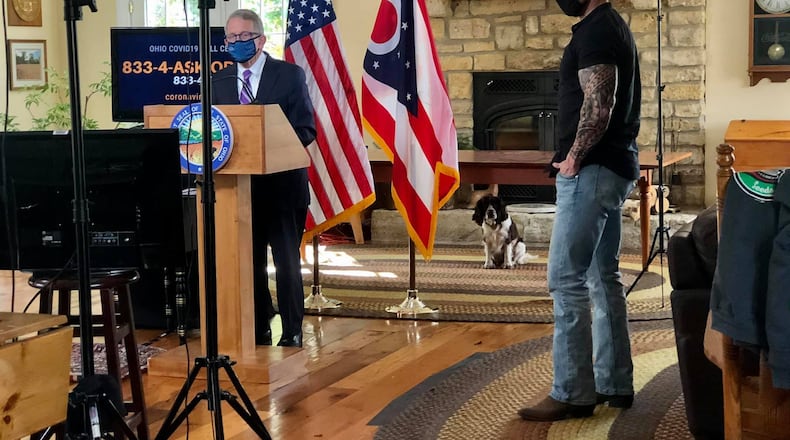 Gov. Mike DeWine and videographer Eric Porter get ready for a coronavirus press briefing to be broadcast from DeWine's Greene County farm. First Dog Dolly looks on.