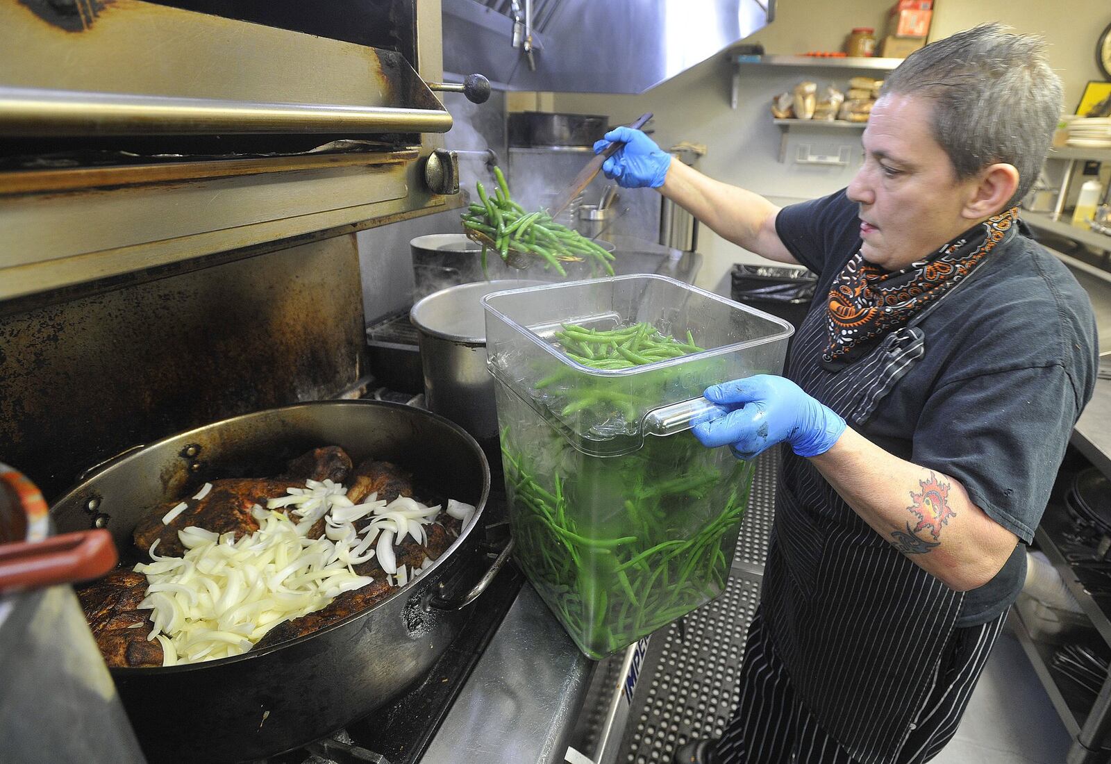 Elizabeth Liz Valenti, the head chef, at Wheat Penny Oven & Bar, on Wayne Ave. works nearly 15 hours a day preparing food for takeout orders through the day. MARSHALL GORBYSTAFF