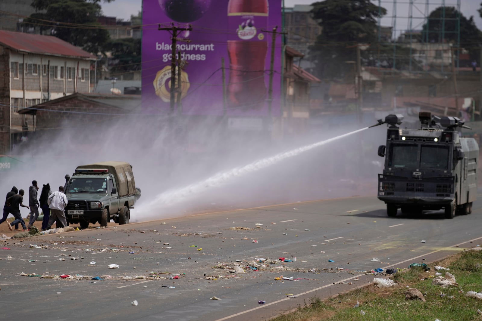 Riot police scatter protesters with water canons during the historic 1990 "Saba Saba", a Swahili word that means seven seven, protests for democratic reforms in the Kangemi slum of Nairobi, Kenya Monday, July 7, 2025. (AP Photo/Brian Inganga)