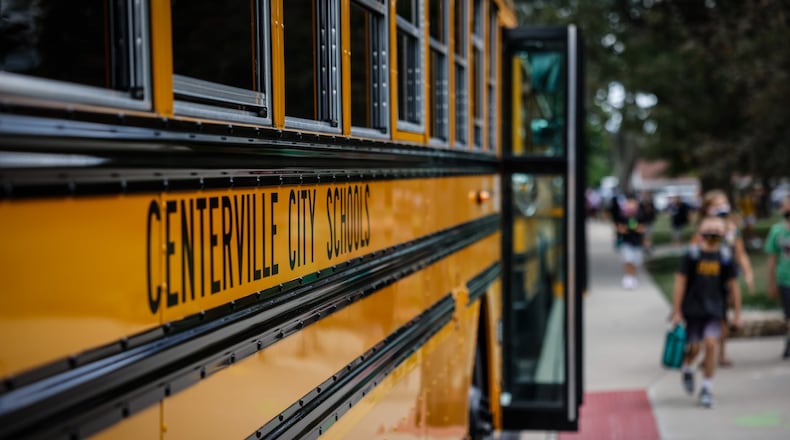 Children at Cline Elementary School in Centerville load into buses after the first day of school Wednesday August 18, 2021. All of the kids were wearing masks. JIM NOELKER/STAFF