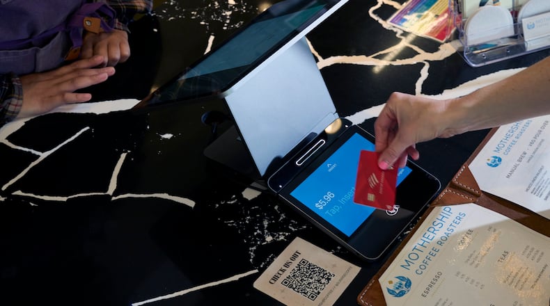 FILE — A customer pays with a credit card at a coffee shop. (Bridget Bennett/The New York Times)