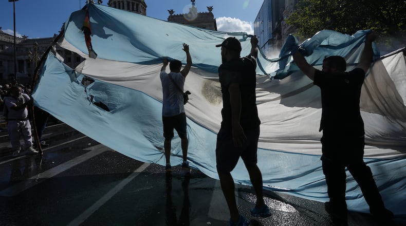 Protesters rally during a march by trade unions and opposition groups against a labor reform bill proposed by President Javier Milei's government in Buenos Aires, Argentina, Thursday, Feb. 19, 2026. (AP Photo/Rodrigo Abd)