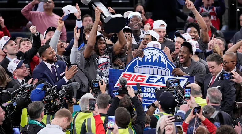 St. John's forward Zuby Ejiofor and players of St. John's raise a tournament trophy after an NCAA college basketball game against UConn in the championship of the Big East tournament, Saturday, March 14, 2026, in New York. (AP Photo/Yuki Iwamura)