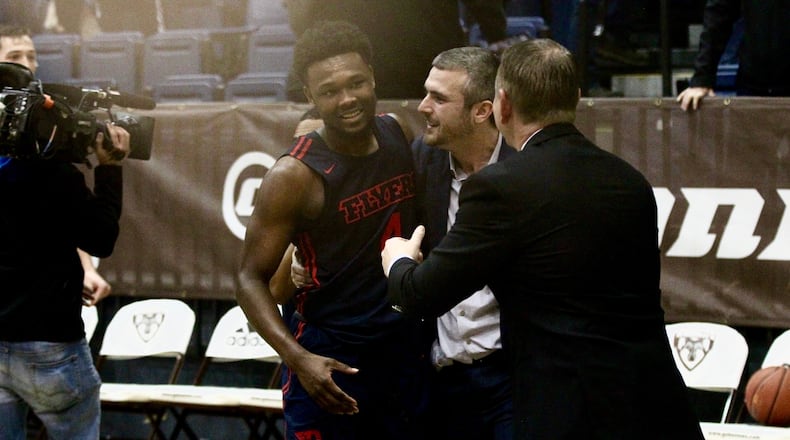 Dayton’s Jordan Davis is congratulated by coaches Brett Comer, center, and Donnie Jones, right, after a victory against St. Bonaventure on Saturday, Jan. 19, 2019, at the Reilly Center in Olean, N.Y. David Jablonski/Staff