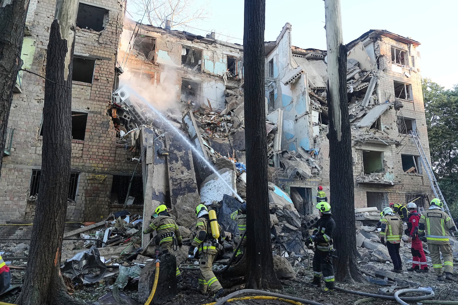 Firefighters work to extinguish a fire in an apartment building after Russian attack in Kyiv, Ukraine, early Monday, June 23, 2025. (AP Photo/Efrem Lukatsky)