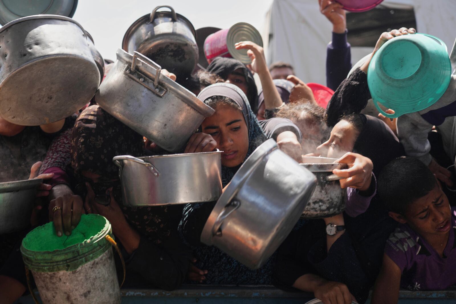 Palestinians struggle to get donated food at a community kitchen in Khan Younis, Gaza Strip, Monday, May 5, 2025. (AP Photo/Abdel Kareem Hana)