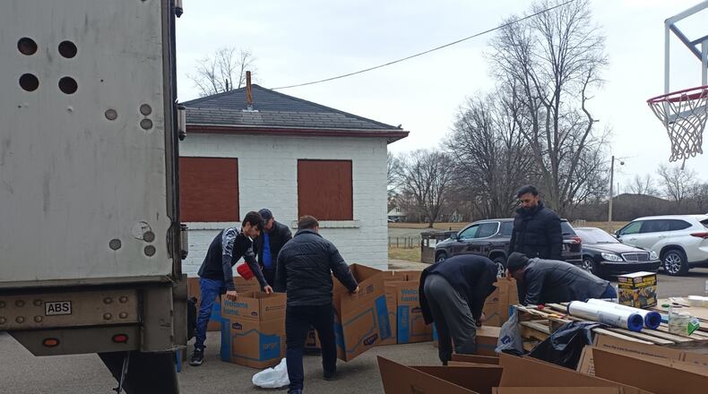Members of the Osman Gazi Mosque and Dayton's Turkish community package donations, including clothing items, boots, and blankets, on Tuesday to be sent to Turkey for victims of Monday's 7.8 earthquake. SAMANTHA WILDOW\STAFF