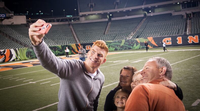Cincinnati Bengals quarterback Andy Dalton takes a picture with some fans who attended his “Night in the Jungle” event that raised $30,000 for his foundation Thursday night.