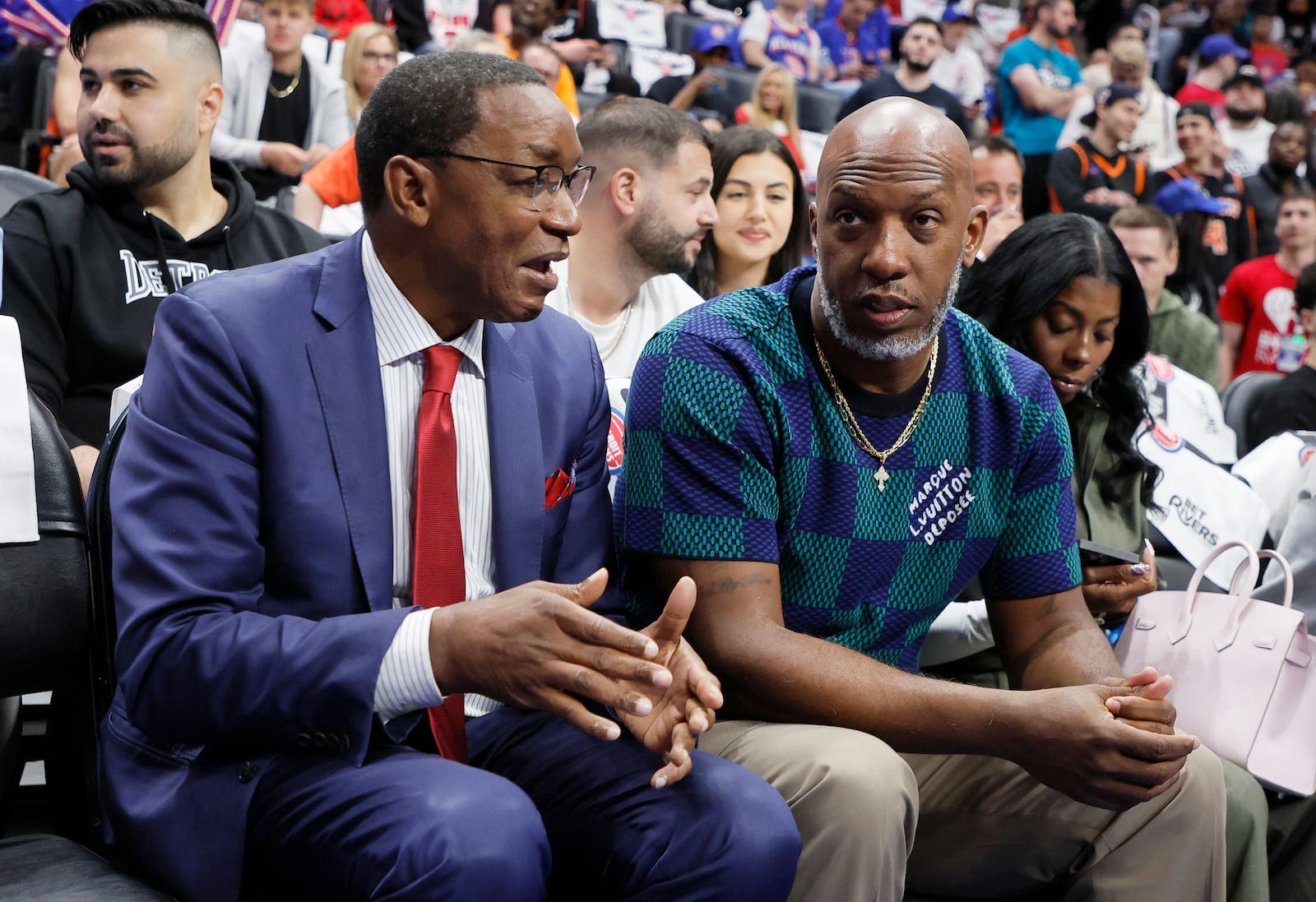 Former Detroit Pistons players Isiah Thomas, front left, and Chauncey Billups, front right, visit before Game 4 of an NBA basketball first-round playoff series against the New York Knicks Sunday, April 27, 2025, in Detroit. (AP Photo/Duane Burleson)