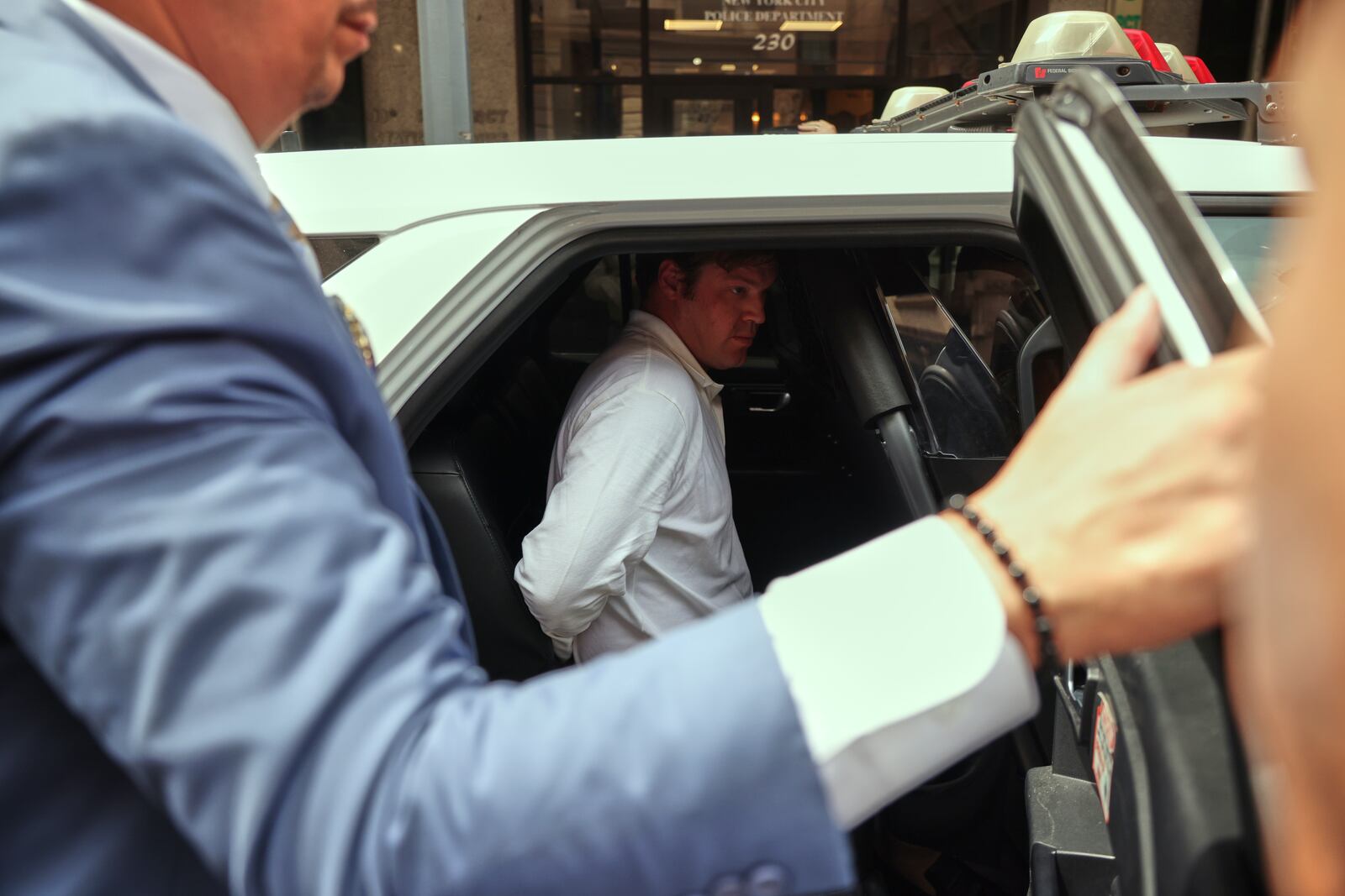 William Duplessie, right, is escorted out of the New York Police 13th Precinct after turning himself in on charges of kidnapping and false imprisonment, Tuesday, May 27, 2025, in New York. (AP Photo/Yuki Iwamura)