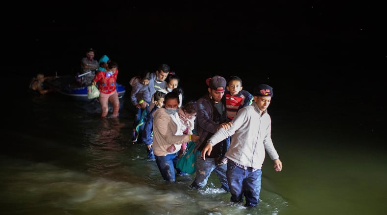 FILE - Migrant families wade through shallow waters toward Roma, Texas, March 24, 2021. (AP Photo/Dario Lopez-Mills, File)