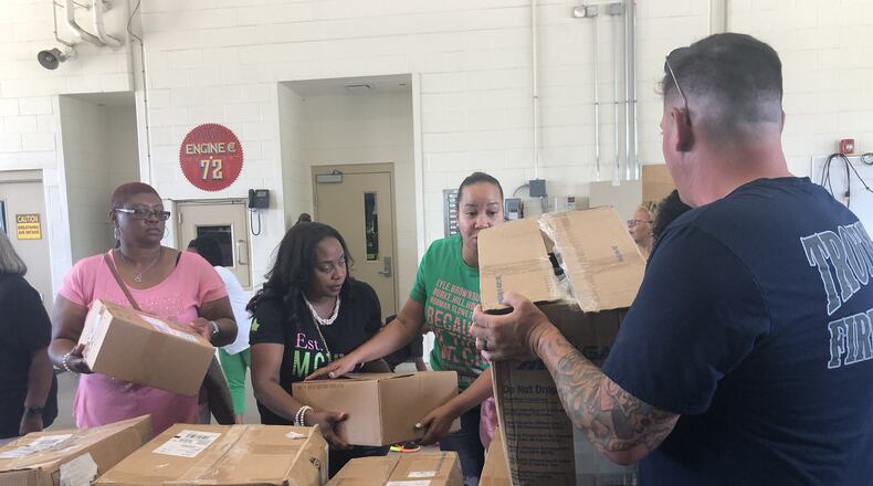 Volunteers with the Alpha Kappa Alpha help unload a bus full of school supplies to be donated to Trotwood students.