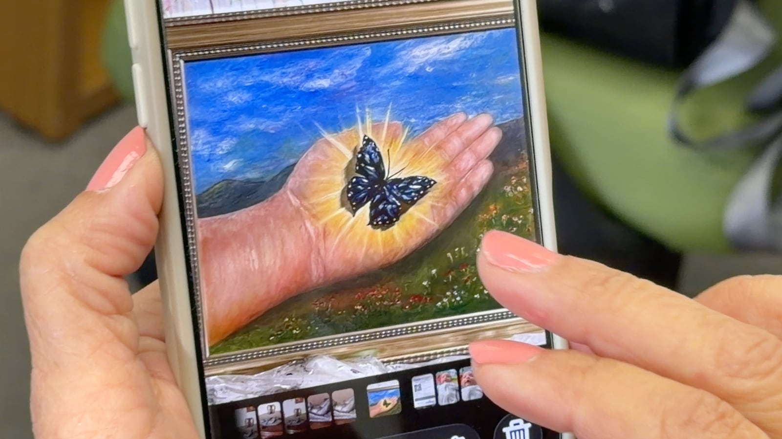 On her phone, Martha-Jeannette Rodriguez shows one of her many art projects. This one depicts a gleaming butterfly resting on her palm, a symbol of transformation. DAVID SHERMAN/STAFF
