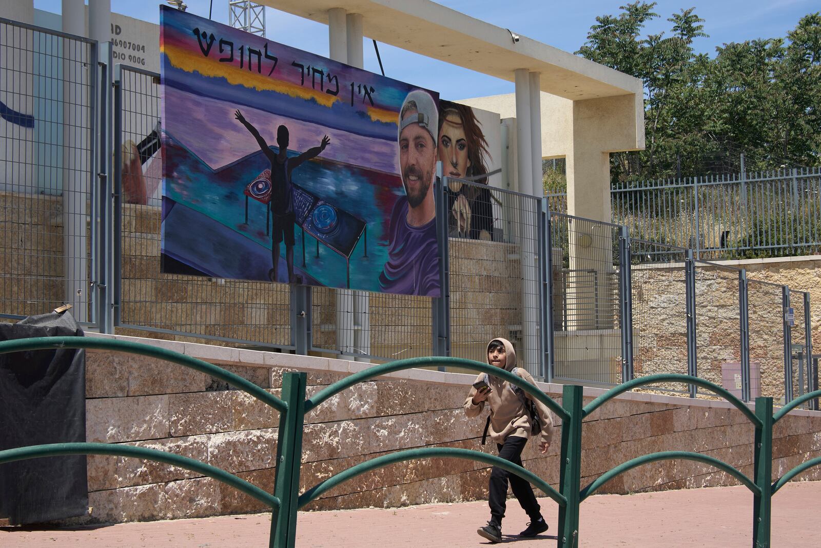 A painting of Elkana Bohbot, who was abducted and brought to Gaza on Oct. 7, 2023, is hung in his family's hometown of Mevaseret Zion, Israel, Wednesday, May 7, 2025. Hebrew reads, "There is no price for freedom." (AP Photo/Maya Alleruzzo)