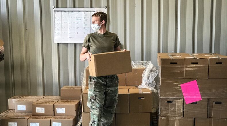 Volunteers and The Foodbank staff distribute food at the last mass distribution at the Nutter Center in April. MARSHALL GORBY/STAFF