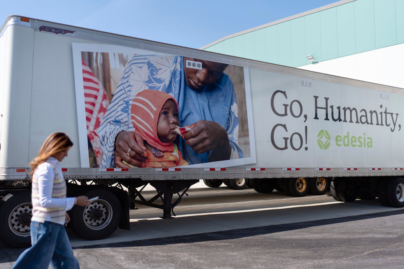Edesia Nutrition CEO Navyn Salem walks past a delivery truck sitting idle at the company's North Kingstown, R.I. facility where they make Plumpy'Nut, a nutritional lifesaving peanut paste sent to malnourished children worldwide, Friday, March 14, 2025. (AP Photo/David Goldman)