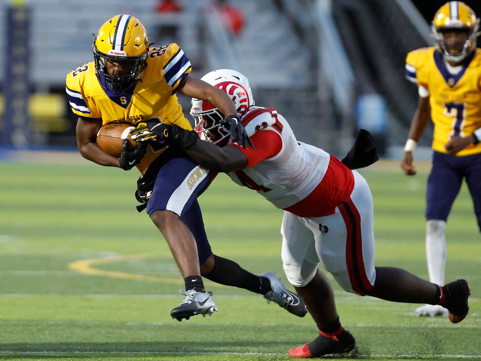 Springfield's Tre Montgomery is tackled by Trotwood's Jamarcus Whyce. BILL LACKEY/STAFF