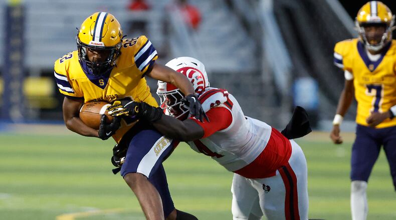 Springfield's Tre Montgomery is tackled by Trotwood's Jamarcus Whyce. BILL LACKEY/STAFF
