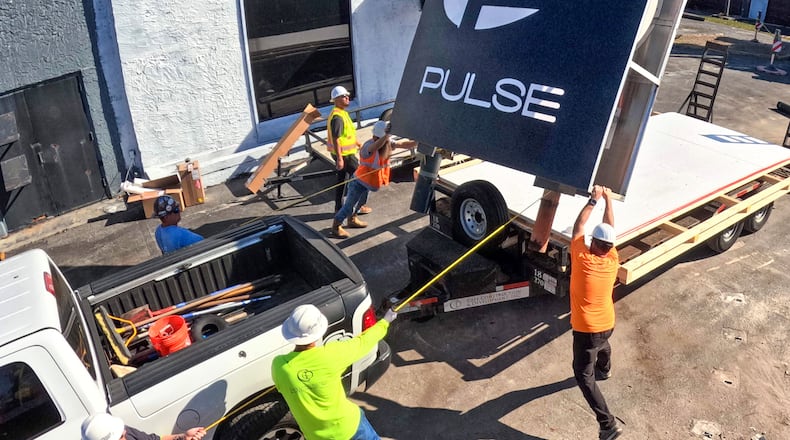 The sign for the Pulse nightclub is removed by workers, Wednesday, March 11, 2026, at the memorial site of the 2016 mass shooting in Orlando, Fla., that killed 49. The sign will be preserved and displayed at the permanent memorial, slated to open in Fall of 2027. (Joe Burbank/Orlando Sentinel via AP)