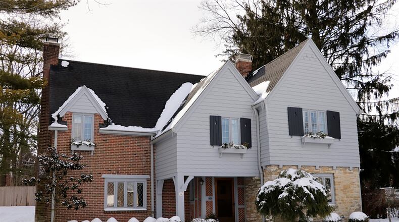 The 2-story home with 3 bedrooms and about 2,200 sq. ft. of living space has a high-peak roofline and decorative window boxes that accent the brick, stone and wood exterior. The home also features a finished basement and a 4-season room. CONTRIBUTED PHOTO BY KATHY TYLER