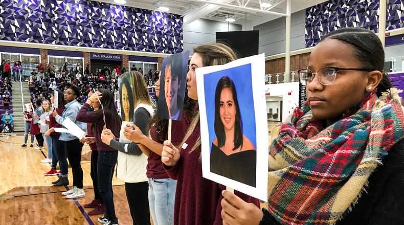 Middletown High School student Jasmynn Thomas, right, holds a picture of Parkland shooting victim Carmen Schentrup as students at Middletown High School participated in events Wednesday, March 14 as part of National Walk Out efforts to commemorate the deaths of 17 students who died from gunfire at a Parkland, Fla. high school. Students filled the Wade E. Miller Arena and 17 students read biographies of those killed in the Parkland school shooting. NICK GRAHAM/STAFF