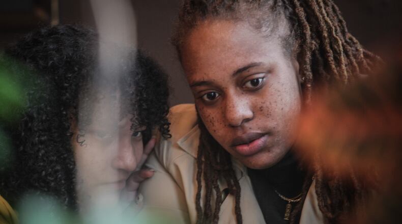 Daj'za Demmings, right and her stepdaughter, Adrielle Tolentino enjoy time together at Wholly Grounds Coffee House in Dayton. STAFF/JIM NOELKER