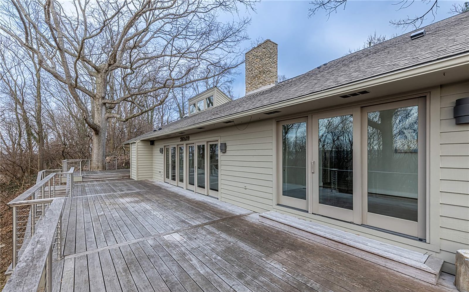 The back of the home features a wood deck with railings that extends across the entire back of the home and overlooks the wooded lot. CONTRIBUTED