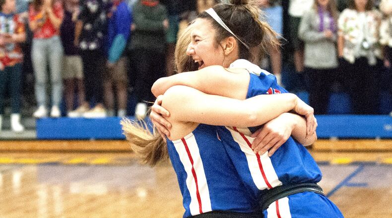 Carroll’s Ava Lickliter (right) and Jillian Roberts celebrate their 41-38 victory over Roger Bacon in the Division II regional final Friday night at Springfield High School. The Patriots will play in the state tournament for the second straight year. Jeff Gilbert/CONTRIBUTED