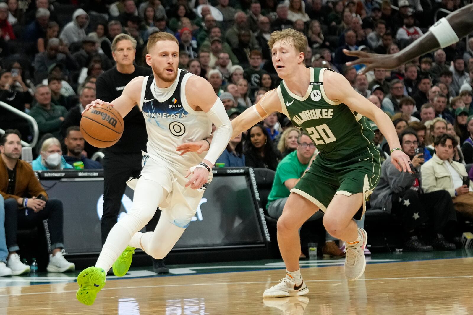 Minnesota Timberwolves' Donte DiVincenzo (0) drives to the basket against Milwaukee Bucks' AJ Green during the second half of an NBA basketball game Tuesday, April 8, 2025, in Milwaukee. (AP Photo/Aaron Gash)