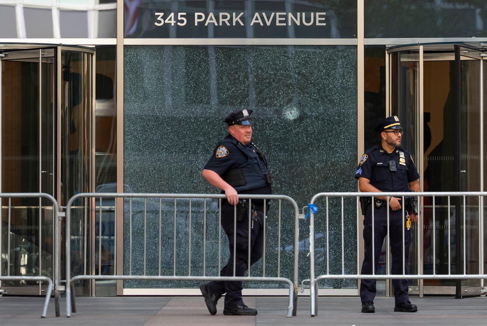 Police officers stand in front of a door with a bullet hole at scene of Monday's deadly shooting, Tuesday, July 29, 2025, in New York. (AP Photo/Yuki Iwamura)