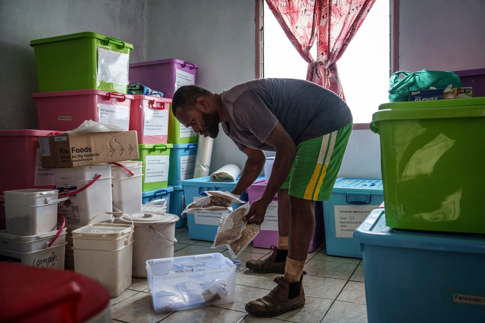 Kaltang Laban organizes preserved food as part of a Save the Children project on Pele Island, Vanuatu, Thursday, July 17, 2025. (AP Photo/Annika Hammerschlag)