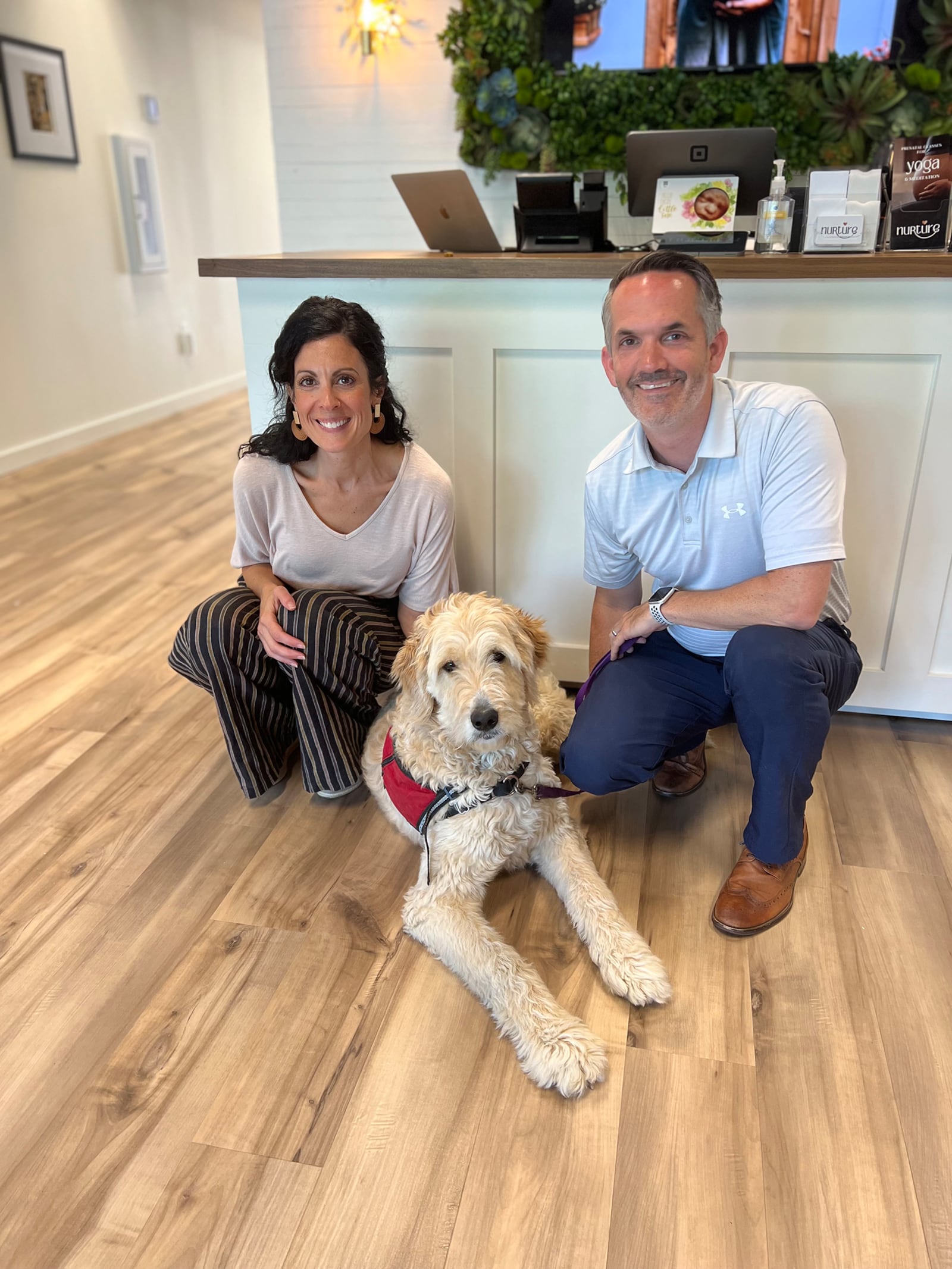 Erica (Left) and Scott Paulson at the brick-and-mortar location of Nurture in Cincinnati with a weekend foster dog, Cashew, in training with 4-Paws for Ability. CONTRIBUTED