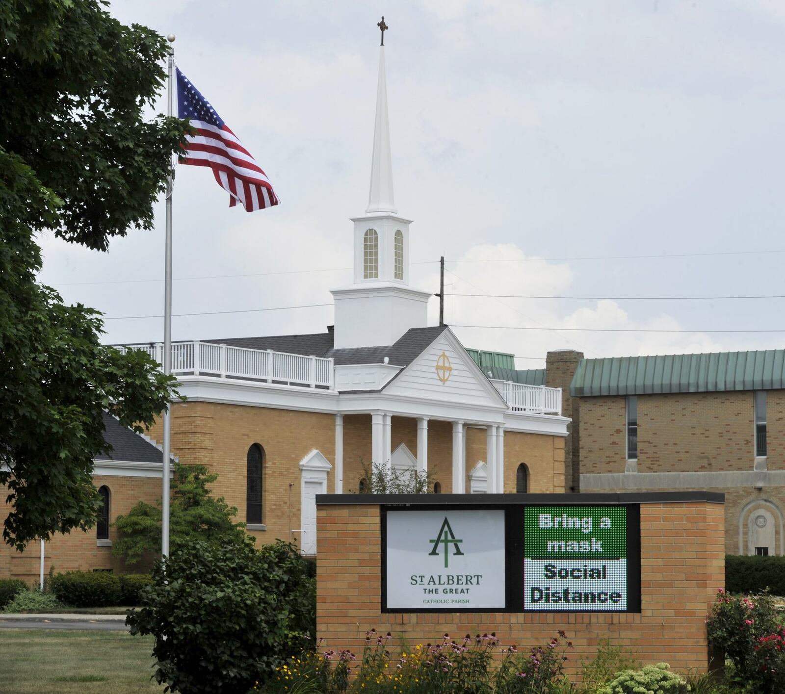 The sign outside St. Albert The Great Catholic Church in Kettering, tells churchgoers to, bring a mask and to social distance while at the parish. MARSHALL GORBYSTAFF